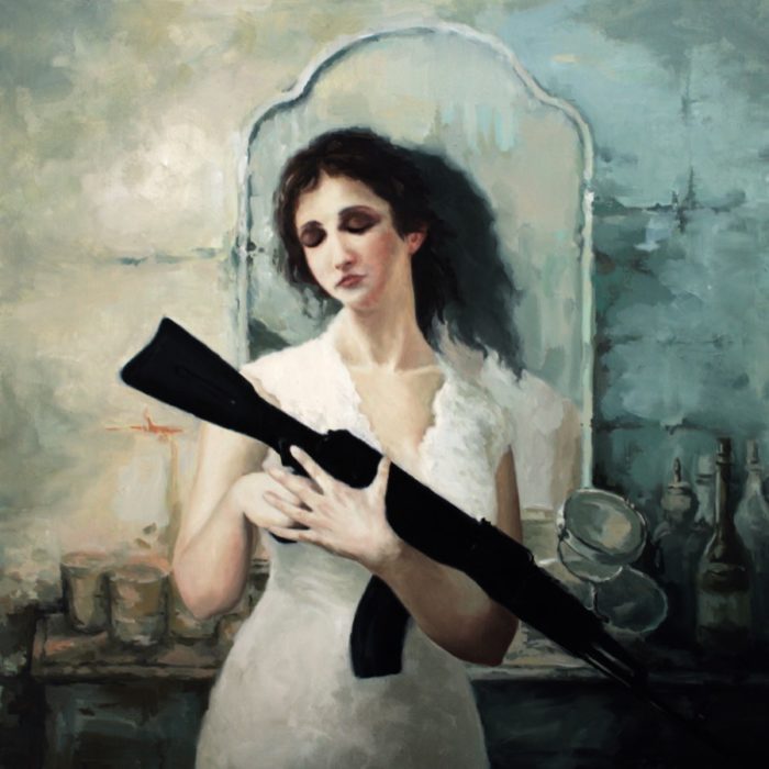 Woman holding an AK rifle in front of a dressing table with mirror
