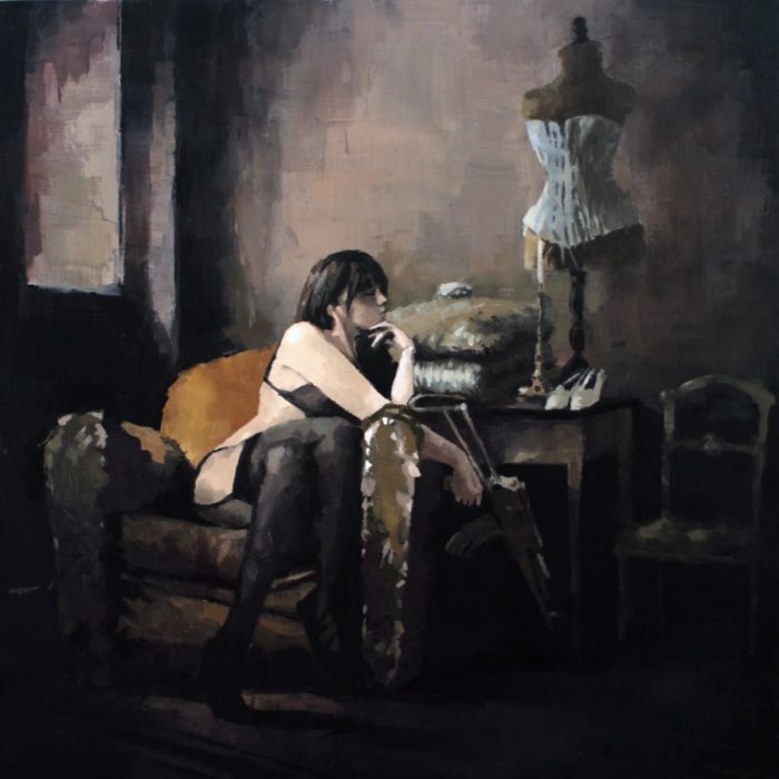 Woman sitting in a couch holding an AK rifle in a dark boudoir room
